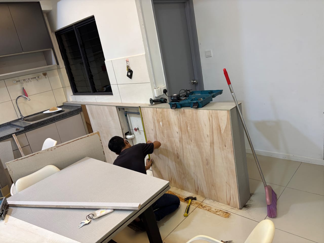 Carlex Enterprise worker repairing kitchen cabinetry